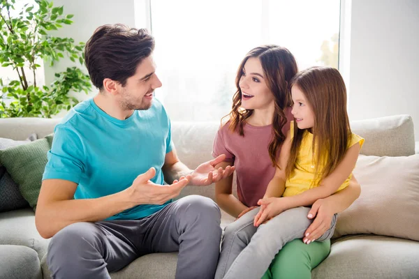 Foto de tres personas sentarse sofá padre decir noticias madre esposa pequeño niño escuchar emocionado en casa en el interior — Foto de Stock