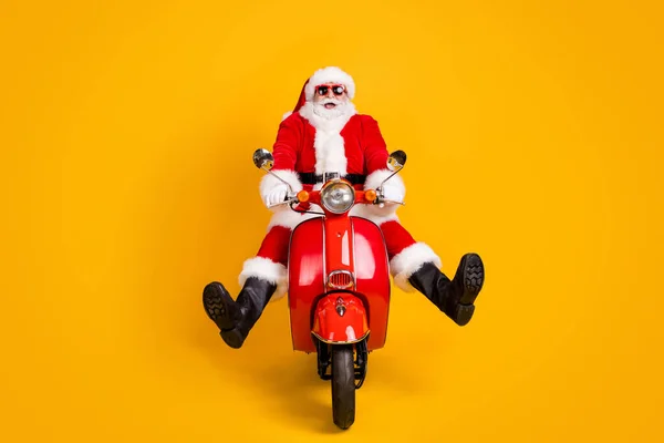 Portrait de son il agréable drôle ludique enfantin comique hilarant Père Noël équitation cyclomoteur avoir du plaisir à tromper vitesse rapide isolé brillant vif vibrant fond de couleur jaune — Photo