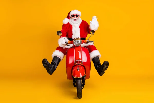 Retrato dele ele agradável engraçado cômico alegre alegre alegre Santa andar de bicicleta do motor viajando se divertindo acenando Olá grimacing velocidade rápida isolado brilhante brilho vívido cor amarela vibrante fundo — Fotografia de Stock