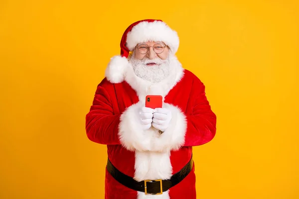 Photo jolly Holly szara broda bajki świętować x-mas Boże Narodzenie 2021 nowyrok używać smartfona typu tekst gratulacje nosić czerwony kostium odizolowany jasny połysk kolor tło — Zdjęcie stockowe