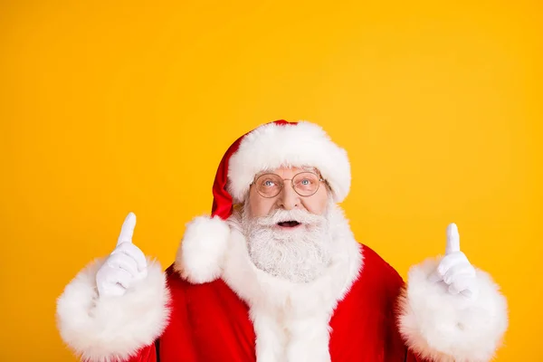 Close up photo of astonished grey beard Santa Claus point finger up copyspace present x-mas magic cud nowyear ads wear cap headwear isolated over bright shine color background — Zdjęcie stockowe