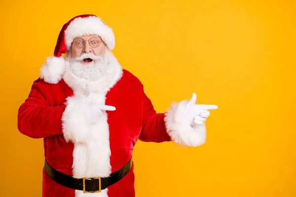 Foto verbaasd baard santa claus onder de indruk x-mas noel kerst advertenties korting punt vinger copyspace slijtage cap hoofddeksel stijl stijlvolle trendy kostuum geïsoleerde heldere glans kleur achtergrond — Stockfoto