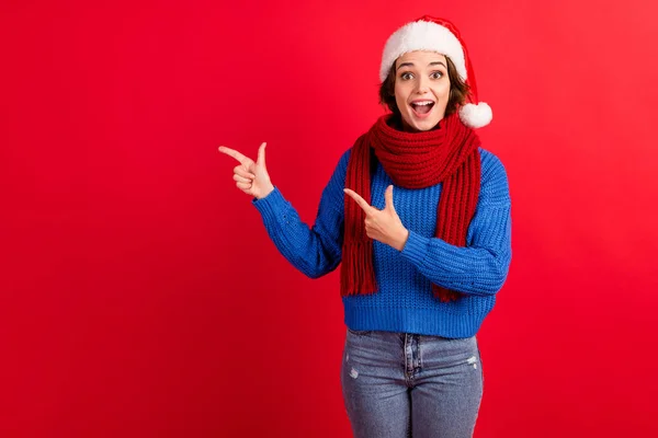 Surprised shocked girl in santa claus headwear cap point finger copyspace impressed season tradition discount wear blue knitted pullover denim jeans isolated bright shine color background — Stock Photo, Image