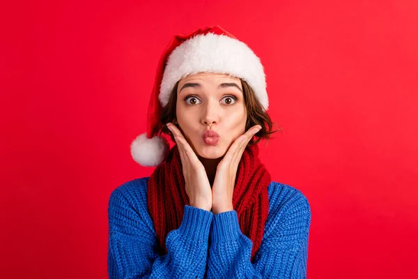 Портрет вражений кумедною милою дівчиною в головній убірці Санта-Клауса вразив різдвяні магічні знижки торкаються рук обличчя щоки надіти синій светр ізольований червоний яскравий кольоровий фон — стокове фото