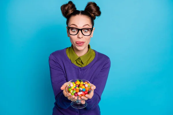 Primer plano retrato de agradable atractivo divertido infantil adicto hambriento alegre chica sosteniendo en las manos caramelos lamiendo labio aislado en brillante brillo vivo vibrante azul verde verde azulado turquesa color de fondo —  Fotos de Stock