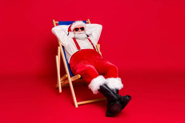 Portret van zijn hij mooie knappe bebaarde Santa vader hipster guy zitten in stoel rusten ontspannen besteden weekend vrije tijd vrijetijdsbesteding geïsoleerde helder levendige glans levendige rode kleur achtergrond — Stockfoto