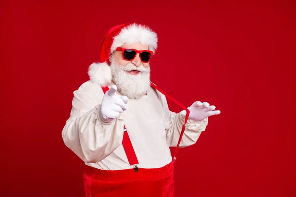 Portret van zijn hij mooie knappe vrolijke koele inhoud bebaarde vet Kerstman trekken bretels wijzend naar u met plezier uit te nodigen feestelijke geïsoleerde helder levendige glans levendige rode kleur achtergrond — Stockfoto