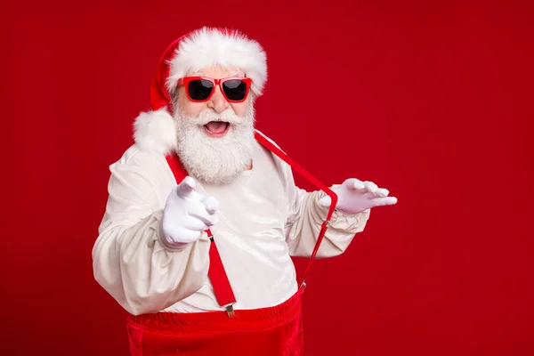 Close-up portret van zijn hij mooi knap vrolijk opgewonden baard vet Kerstman trekken bretels wijzend naar u met plezier uit te nodigen datum geïsoleerd helder levendig glans levendig rood kleur achtergrond — Stockfoto