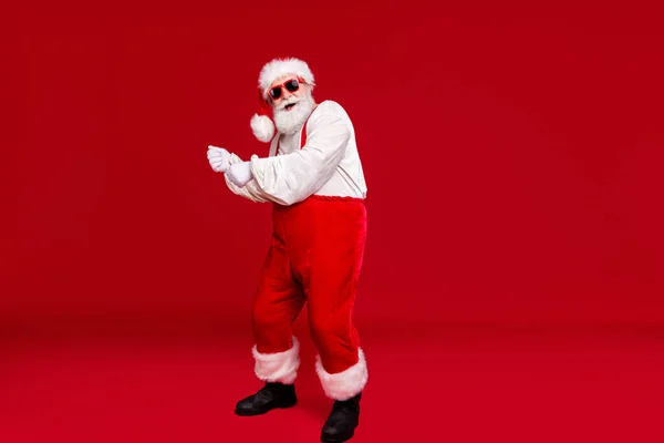 In voller Länge Körpergröße Ansicht seiner schönen fröhlich lustig positive bärtige Weihnachtsmann Hipster tanzen Spaß beim Tragen festlichen Outfit Sonnenbrille isoliert hell lebendigen Glanz lebendige rote Farbe Hintergrund — Stockfoto