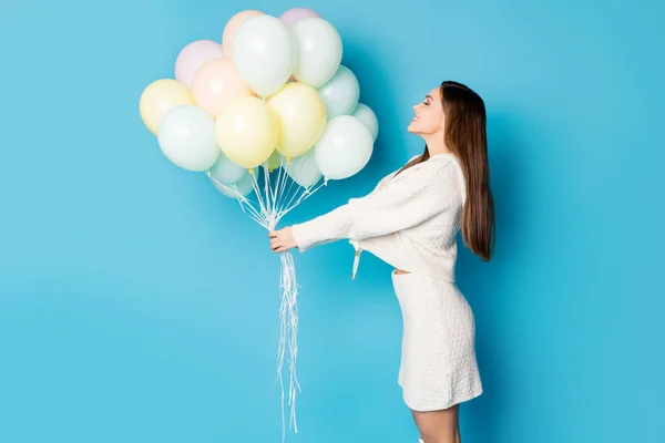 Strona profil zdjęcie uroczy wesoły zawartość dziewczyna uzyskać wiele balonów od jej chłopaka w rocznicę cieszyć się życzeniem nosić strój trend izolowane na tle niebieskiego koloru — Zdjęcie stockowe
