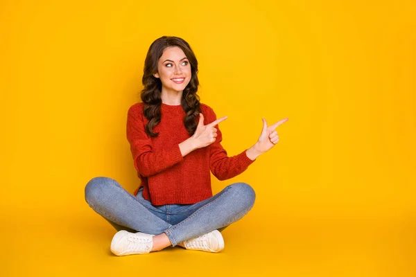 Foto lucu menarik wanita duduk kaki lantai menyeberang langsung sisi jari kosong ruang menunjukkan produk baru mengenakan pakaian santai terisolasi warna kuning cerah latar belakang — Stok Foto