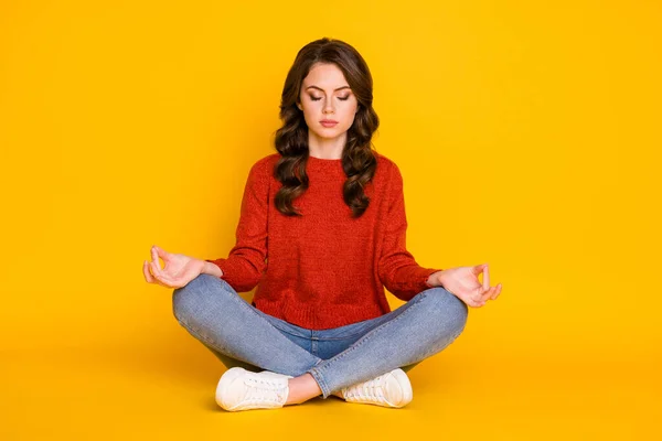 Retrato dela ela agradável atraente linda sonhadora focada menina de cabelos ondulados sentado na posição de lótus meditando isolado no brilho vívido brilhante vibrante cor amarela fundo — Fotografia de Stock