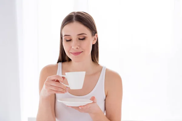 Primeros planos foto de atractiva adorable joven cuarentena tiempo increíble mañana energética buen humor bebida fresca café caliente porcelana vidrio ojos cerrados permanecer en casa comodidad dormitorio interior —  Fotos de Stock