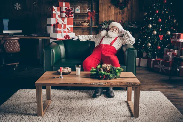 Full size photo of jolly holly santa claus sit couch watch x-mas christmas film movie have cozy table with milk glass ginger cookies wear red costume in house indoors newyear decoration — Stock Photo, Image