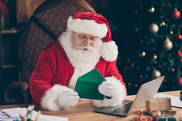 Photo focused santa claus prepare x-mas christmas night midnight event sit table open enveloppe verlanglijstje lezen brief dragen pet in huis binnen met nieuwjaar decoratie kerstballen speelgoed — Stockfoto