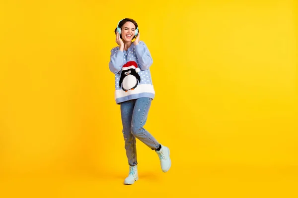 Full body photo of attractive lady youth student party newyear listen cool modern technology earphones radio wear ugly ornament sweater pullover jeans boots isolated yellow color background — Stock Photo, Image
