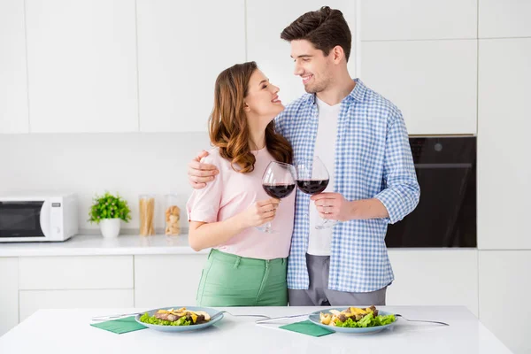 Portrait de son il elle deux gentilles personnes gaies gaies affectueuses passer la journée romantique manger de la nourriture savoureuse restaurant domestique boire du vin rouge dans la lumière blanche cuisine intérieure maison appartement — Photo