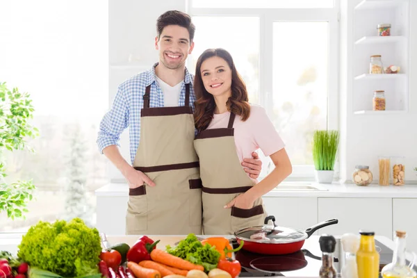 Retrato de amistad positiva pareja vegana cónyuges disfrutar de pasatiempo familiar cocina día abrazo listo preparar comida de nutrición orgánica en casa cocina interior — Foto de Stock