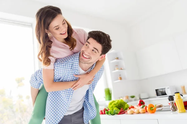 Portrait of tender gentle passionate two people couple vegan man hug piggyback woman enjoy weekend dish meal dinner preparation have rest relax leisure in kitchen house indoors — Stock Photo, Image