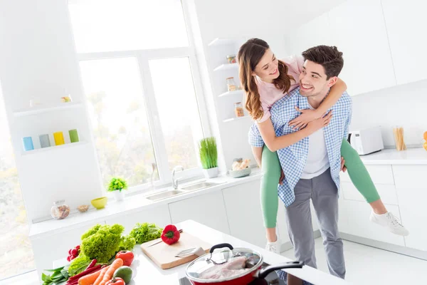 Två personer funky makar passionerad man bära piggyback flicka njuta hobby helg middag middag lunch förberedelse kram i kök hus inomhus — Stockfoto
