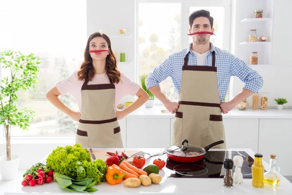 Двоє смішних людей насолоджуються хобі приготуванням їжі мають червоний гарячий перець чилі уявіть фальшивий вуса комічний гумор жарти готуйте вечерю в кухонному будинку в приміщенні — стокове фото