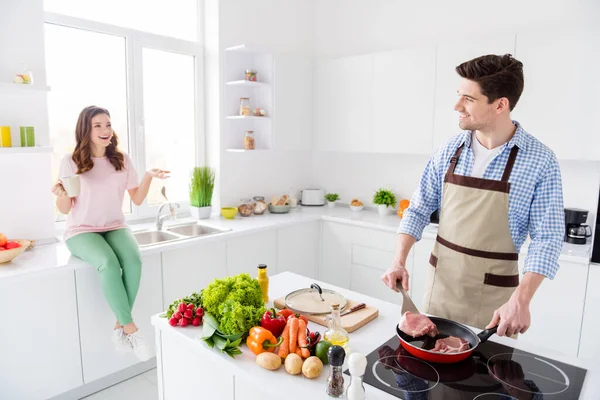 Porträtt av två trevliga vackra glada glada glada makar gör inhemska välsmakande hemlagad maträtt har kul i ljus vit interiör kök hus lägenhet inomhus — Stockfoto