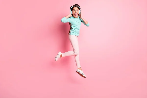 Foto de cuerpo entero tamaño de niña hispana loca saltando gritando usando auriculares aislados en el fondo de color rosa —  Fotos de Stock