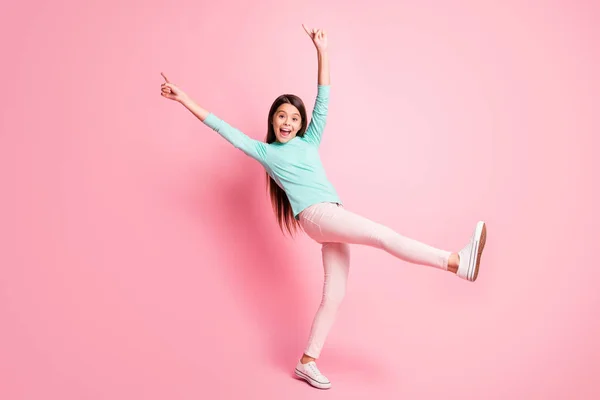 Teljes test méretű fotó aranyos kis spanyol hölgy hosszú frizura tánc emelje fel a kezét fel közvetlen ujjak viselni türkiz pulcsi nadrág fehér tornacipő elszigetelt rózsaszín háttér — Stock Fotó