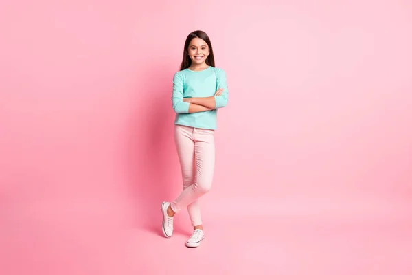 Foto de longitud completa de bastante dulce pequeña señora latina largo peinado brazos cruzados auto-seguro fresco seguro de usar sudadera de color turquesa pantalones zapatillas aisladas de color rosa fondo — Foto de Stock