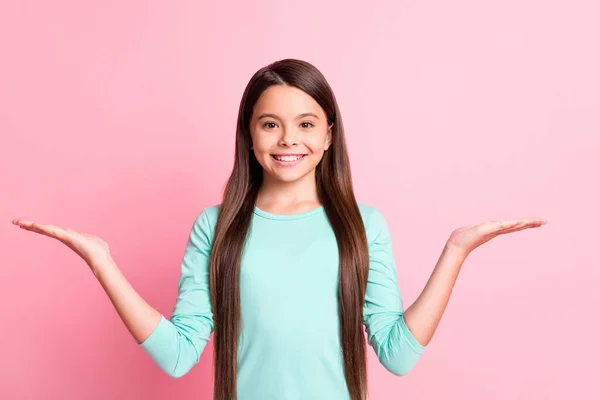 明るい甘い小さなヒスパニック系の女性の写真長い髪を上げる手を保持します空のスペース提案は笑顔を提供しています示していますターコイズのスウェットシャツ孤立ピンク色の背景 — ストック写真
