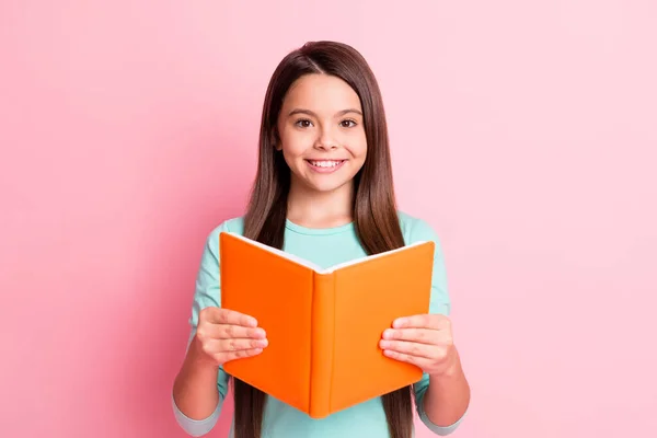 Foto de muito doce pequena senhora hispânica longos braços penteado segurar laranja diário radiante sorriso brilhante preparar ler em voz alta desgaste turquesa camisola teal isolado cor rosa fundo — Fotografia de Stock