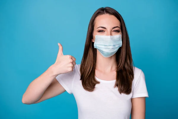 Portrait of positive cheerful girl enjoy rejoice perfect covid infection stop ads promo showing thumb up sign wear medical mask clothes isolated blue color background — Stock Photo, Image