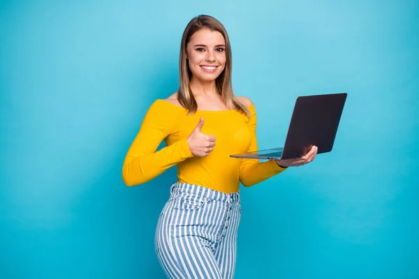 Porträtt av henne hon snygg attraktiv härlig skicklig glad glad glad flicka håller i händerna laptop arbetar visar tummen annons isolerad på ljusa levande glans levande blå färg bakgrund — Stockfoto