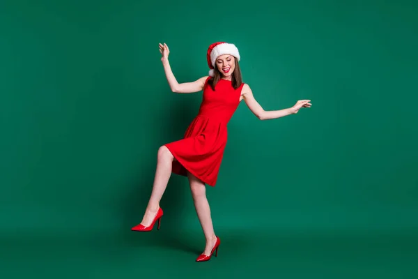 Foto de comprimento total da menina positiva em santa claus headwear tem ano novo x-mas festa festa dança desgaste vestido stilettos isolado sobre cor verde fundo — Fotografia de Stock