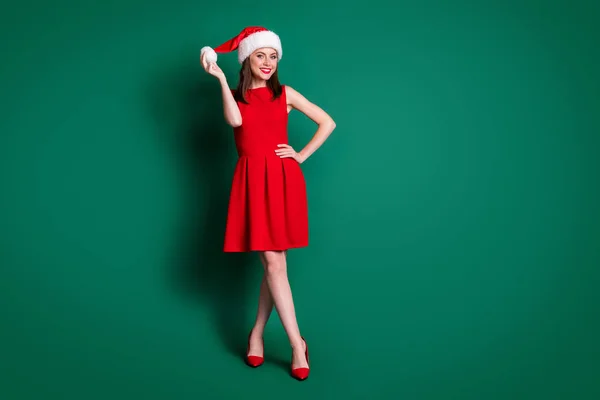 面白い魅力的な女性の新年パーティーのフルサイズの写真2021お祝いムードホールド手遊びでキャップ帽子ザボン着用赤ミニドレス衣装ステッレット隔離された緑の色の背景 — ストック写真