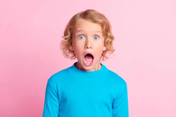 Fotografie malého neočekávaně otevřených úst nosit modré rolák košile izolované pastel růžová barva pozadí — Stock fotografie