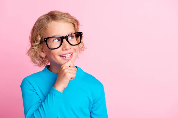 Foto de niño pequeño mano barbilla interesado buscar espacio vacío desgaste gafas cuello alto azul aislado pastel rosa color fondo —  Fotos de Stock