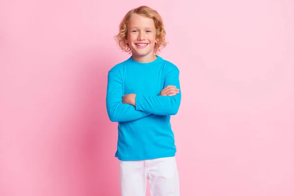 Zdjęcie małego chłopca składane ręce zębaty uśmiech wygląd aparat nosić niebieski golf odizolowany pastelowy różowy kolor tło — Zdjęcie stockowe