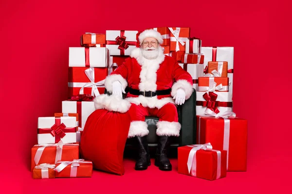 Longitud completa vista del tamaño del cuerpo de su guapo gordo con sobrepeso alegre Santa San Nicolás sentado en la pila de la silla apilar cajas de regalos aislados brillo vivo brillante vibrante color rojo fondo — Foto de Stock