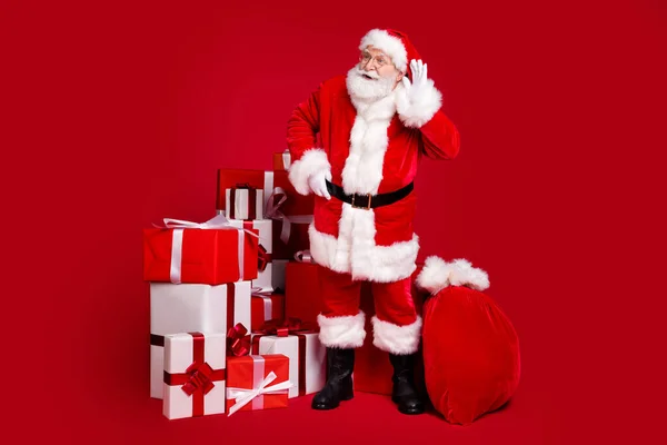 Plná délka tělo velikost pohled na hezký tuk nadváha zvědavý Santa poslech zvukových informací smlouvat hromada dárkových krabic zaslechnout izolované světlé živé lesk pulzující červená barva pozadí — Stock fotografie