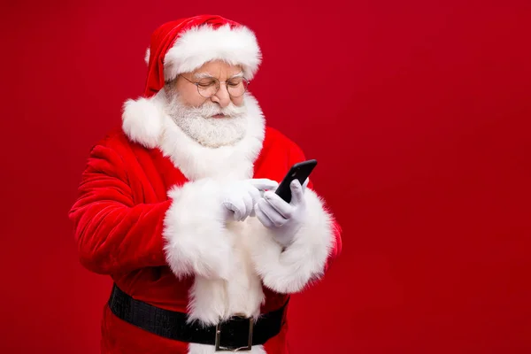 Retrato de seu belo atraente bonito focado Papai Noel usando gadget 5g blog blog post comentário feedback isolado sobre brilhante brilho vívido vibrante cor vermelha fundo — Fotografia de Stock