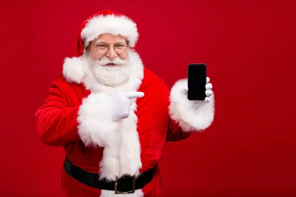 Retrato dele ele agradável atraente bonito alegre Pai Natal demonstrando dispositivo gadget exibir celular 5g serviço venda isolado sobre brilhante vívido brilho vibrante cor vermelha fundo — Fotografia de Stock