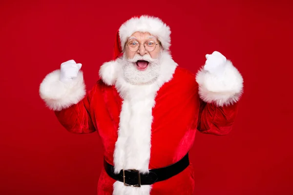 Zdjęcie emeryta dziadek szary broda podnieść pięści otwarte usta wygrać osiągnięcie najlepsze Santa wydarzenie nosić kostium skóra pasek rękawiczki płaszcz okulary nakrycia głowy odizolowany czerwony kolor tło — Zdjęcie stockowe