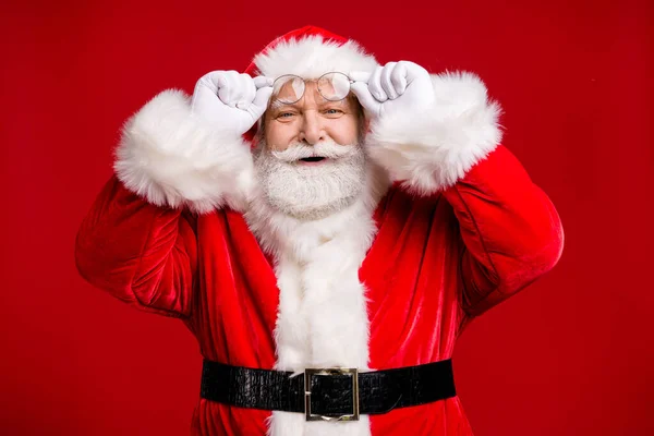 Фото пенсионера старик серая борода снять трюк улыбка найти такси скидка Рождество канун Рождества носить костюм Санта-ремень перчатки пальто очки головной убор изолированный красный цвет фона — стоковое фото
