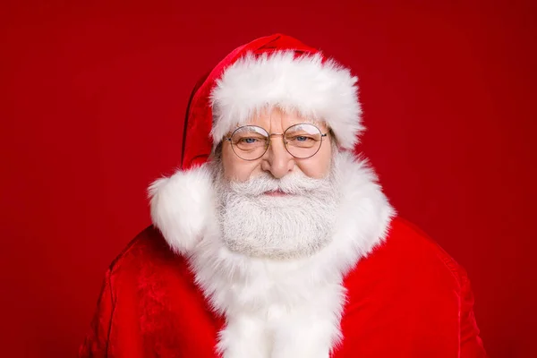 Foto de pensionista anciano sonriente espera elfos ayudan a terminar el trabajo preparar la entrega víspera de Navidad presenta a los niños usan gafas de traje de santa diadema aislado color rojo fondo —  Fotos de Stock