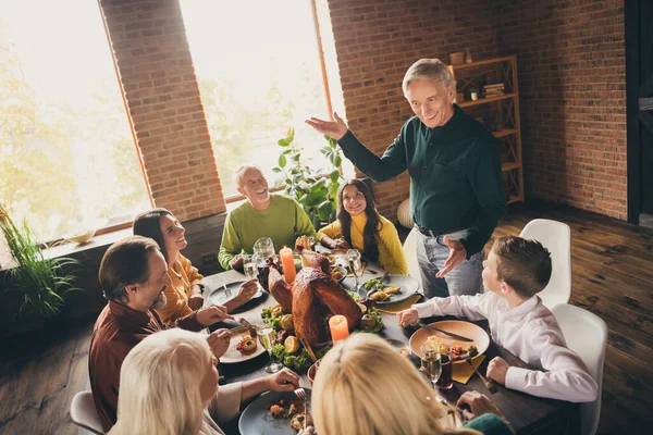 Photo of full family gathering eight people one man uncle stand waving hands smile tell interesting curious occasion served dinner big table turkey generation in evening living room indoors — Stock Photo, Image