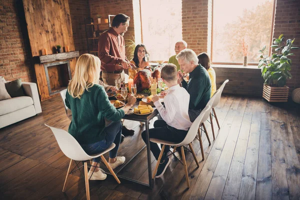 Foto van grote volle mooie blije optimistische positieve mensen genieten van Thanksgiving kalkoen snijden met een mes zitten aan grote grote grote tafel met smakelijke gerechten — Stockfoto