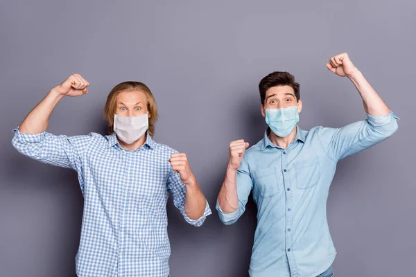 Portrait of two lucky cheerful cheery guys wearing checked shirt respiratory mask best buddy fellow celebrating covid infection victory isolated gray pastel color background — Stock Photo, Image
