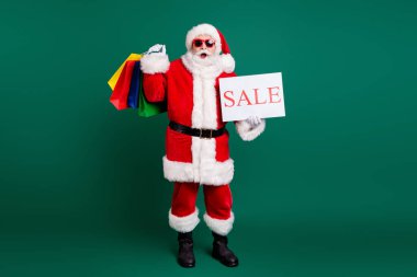 Full length body size view of his he nice fat cheery amazed Santa father carrying gifts presents bargain holding in hand sale promo card season December offer isolated over green color background clipart