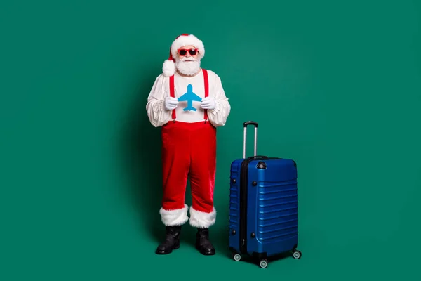 全长体形好看的英俊大胡子时髦超重圣诞老人手握纸片飞机形卡片空中飞机票离境休息季节度假胜地绿颜色孤立的背景 — 图库照片